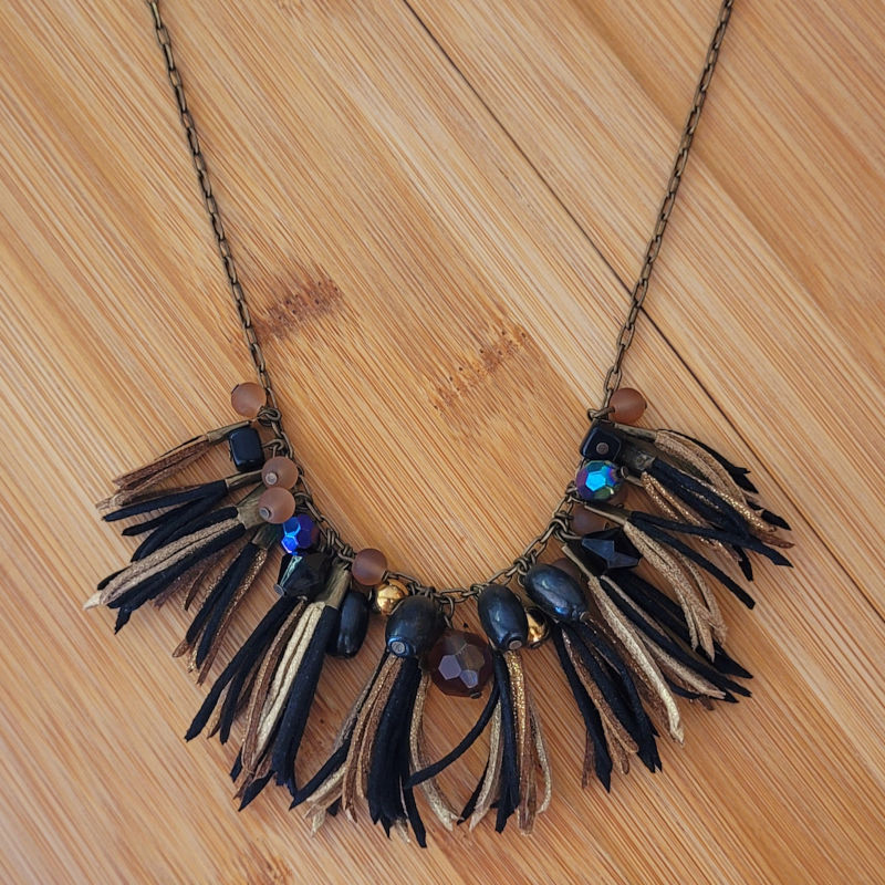Collier chaîne bronze vieilli et assortiment de perles noire beige et pompon de suédine noir beige et doré pailleté