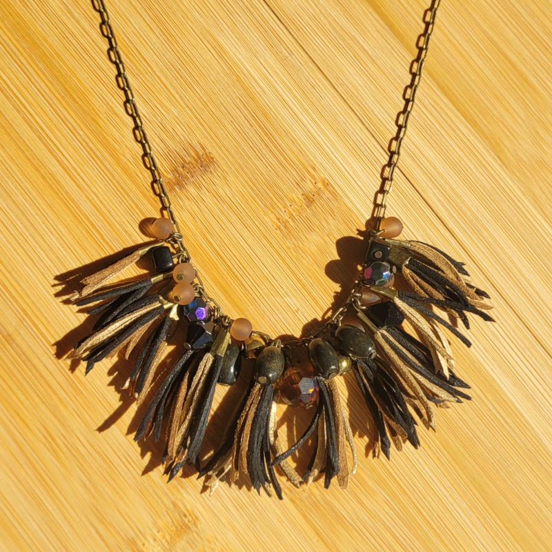 Collier chaîne bronze vieilli et assortiment de perles noire beige et pompon de suédine noir beige et doré pailleté