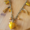 Sautoir chaine acier bronze doré texturée noeud et pampilles de verre feuilleté doré perle suédine et fil de soie orange doré