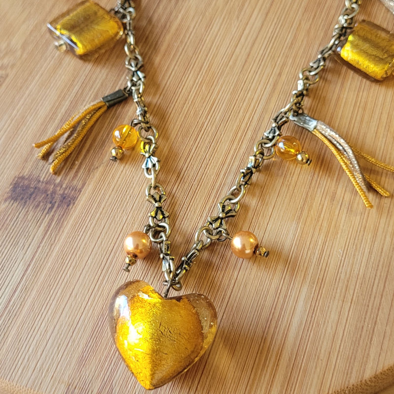Sautoir chaine acier bronze doré texturée noeud et pampilles de verre feuilleté doré perle suédine et fil de soie orange doré
